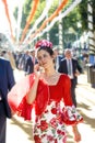 Beautiful Woman dressed in traditional costumes and speaking by mobile phone at the Seville`s April Fair