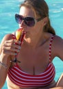 Beautiful woman is drinking a cocktail in bikini relaxing in the swimmin pool Royalty Free Stock Photo