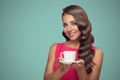 Portrait of beautiful woman drinking coffee on blue background.