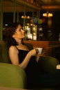 Beautiful woman drinking coffee in cafe. Daily life. Enjoy your life. Brunette girl with cup of tea on the sofa. Cozy lifestyle Royalty Free Stock Photo