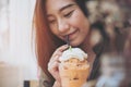 A beautiful woman drinking Thai tea milk shake and whipped cream on the top with straw Royalty Free Stock Photo