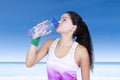 Beautiful woman drinking water at beach Royalty Free Stock Photo