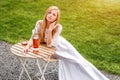 Beautiful woman drinking wine in outdoors cafe. Portrait of young blonde beauty in the vineyards having fun, enjoying a Royalty Free Stock Photo