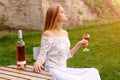 Beautiful woman drinking wine in outdoors cafe. Portrait of young blonde beauty in the vineyards having fun, enjoying a Royalty Free Stock Photo