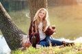 Beautiful woman drinking wine outdoors having picnic in the park. Portrait of young blonde beauty enjoying a glass of Royalty Free Stock Photo