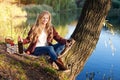 Beautiful woman drinking wine outdoors having picnic in the park. Portrait of young blonde beauty enjoying a glass of Royalty Free Stock Photo