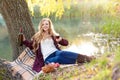 Beautiful woman drinking wine outdoors having picnic in the park. Portrait of young blonde beauty enjoying a glass of Royalty Free Stock Photo