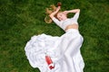 Beautiful woman drinking wine outdoors. Portrait of young blonde beauty in the vineyards having fun, enjoying a glass of Royalty Free Stock Photo