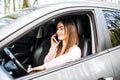 Beautiful woman driver with a lovely smile talking on her mobile phone while seated behind the wheel of the car Royalty Free Stock Photo