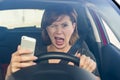 Beautiful woman driving car while texting using mobile phone distracted Royalty Free Stock Photo