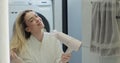 Beautiful woman drying hair with hairdryer after taking shower in bathroom. Concept of well-groomed and beautiful woman. Royalty Free Stock Photo