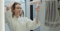 Beautiful woman drying hair with hairdryer after taking shower in bathroom. Concept of well-groomed and beautiful woman. Royalty Free Stock Photo