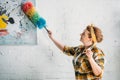 beautiful woman dusting paint on wall