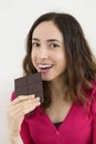 Beautiful woman eating a dark chocolate bar Royalty Free Stock Photo