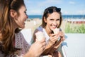 Beautiful woman eating ice cream outside with her friend laughing
