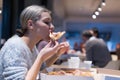 Beautiful woman eating pizza and drinking cola while sitting inside expres restaurant late at night Royalty Free Stock Photo