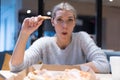 Beautiful woman eating pizza and drinking cola while sitting inside expres restaurant late at night Royalty Free Stock Photo