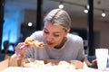 Beautiful woman eating pizza and drinking cola while sitting inside expres restaurant late at night Royalty Free Stock Photo