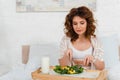 Beautiful woman eating salad near milk Royalty Free Stock Photo