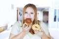 Beautiful woman eats two donuts Royalty Free Stock Photo