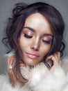 Beautiful woman with elegant hairstyle in white fur coat