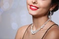Beautiful woman with elegant jewelry on blurred background, closeup Royalty Free Stock Photo