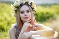 Young beautiful woman with a pleasant smile in  alone in a wreath of fresh flowers walks in a spring flowering park Royalty Free Stock Photo