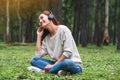 A beautiful woman enjoy listening to music with headphone with feeling happy and relaxed in the park Royalty Free Stock Photo