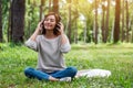 A beautiful woman enjoy listening to music with headphone with feeling happy and relaxed in the park Royalty Free Stock Photo