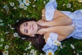 Beautiful woman enjoying daisy field, nice female lying down in meadow of flowers, pretty girl relaxing outdoor, having fun, Royalty Free Stock Photo