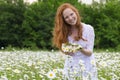 Beautiful woman enjoying daisy field, nice female in the meadow of flowers, pretty girl relaxing outdoor, having fun,holding plant Royalty Free Stock Photo