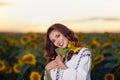 Beautiful woman enjoying nature in the sunflower field at sunset. Traditional clothes. Attractive brunette woman with long and Royalty Free Stock Photo