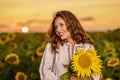 Beautiful woman enjoying nature in the sunflower field at sunset. Traditional clothes. Attractive brunette woman with long and Royalty Free Stock Photo