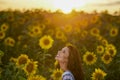 Beautiful woman enjoying nature in the sunflower field at sunset. Traditional clothes. Attractive brunette woman with long and Royalty Free Stock Photo