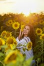Beautiful woman enjoying nature in the sunflower field at sunset. Traditional clothes. Attractive brunette woman with long and Royalty Free Stock Photo