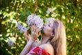 Beautiful Woman Enjoying the Smell of Lilac. Cute Model and Flowers.