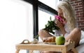 Beautiful Woman Enjoys Flowers at Breakfast