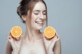 Beautiful woman face with juicy orange on grey background. Natural beauty and spa. Royalty Free Stock Photo