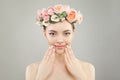 Beautiful woman face. Spa model girl with clear skin, hand with manicured nails and roses flowers on head