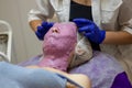 Cosmetic procedure. Woman in beauty salon with mask on her face. Face mask application. A woman makes an alginate mask Royalty Free Stock Photo