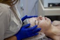 Beauty Clinic.woman gets a professional facial procedure. Beautician makes massage on a woman's face. face renewal Royalty Free Stock Photo