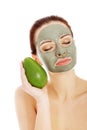 Beautiful woman with facial mask holding avocado. Royalty Free Stock Photo