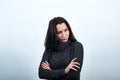 Beautiful woman in fashion black sweater keeping hands crossed, looking serious Royalty Free Stock Photo