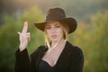 Beautiful woman in fashion hat. Cowgirl in cowboy hat with finger gun. Beautiful girl face closeup, outside portrait of Royalty Free Stock Photo