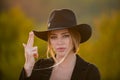 Beautiful woman in fashion hat. Cowgirl with finger gun. Close up face of young stylish woman simulate shooting with and Royalty Free Stock Photo