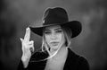 Beautiful woman in fashion hat. Cowgirl with finger gun. Close up face of young stylish woman simulate shooting with and Royalty Free Stock Photo