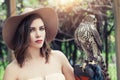 Beautiful woman in fedora hat with bird, outdoors portrait Royalty Free Stock Photo