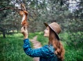 Beautiful woman feeding squirrel in forest