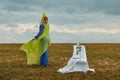 Beautiful woman in the field in blue dress and yellow veil. there is chair in the clearing