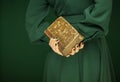 Beautiful woman figure in dark green 50`s dress holding vintage book Royalty Free Stock Photo